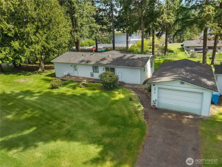 Elevated view highlights the detached garage, driveway, home placement, and peaceful neighborhood setting.