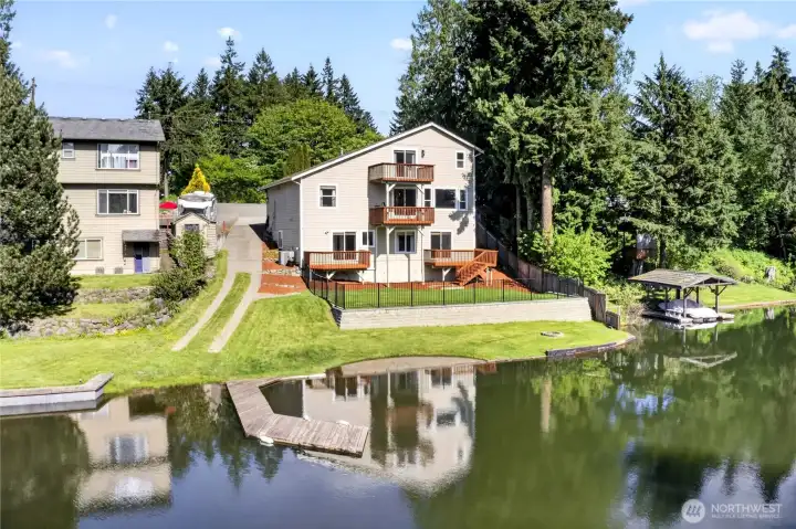 The level, fenced backyard features a firepit for lakeside evenings