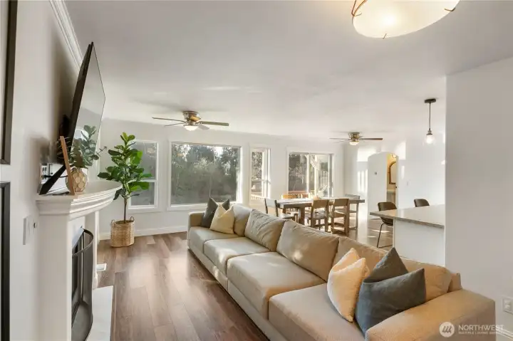 The open great room with cozy gas fireplace and new light fixtures creates the perfect entertaining space