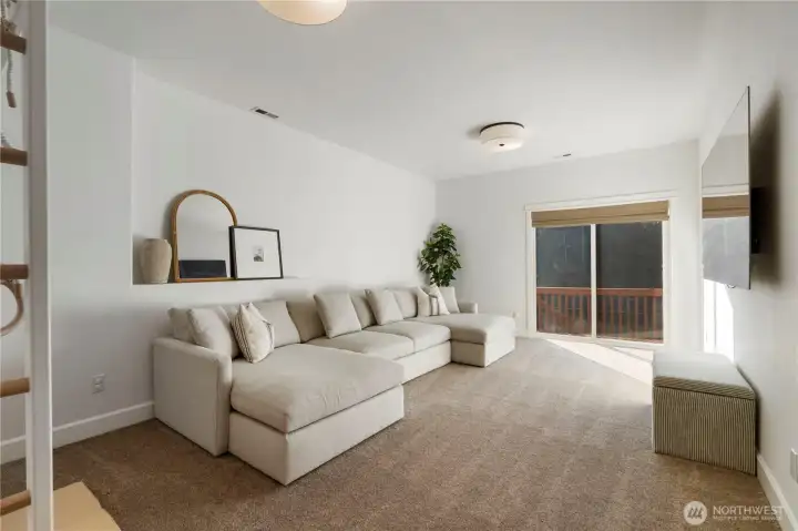 One of two bonus rooms in the lower level featuring high ceilings with access to fenced backyard