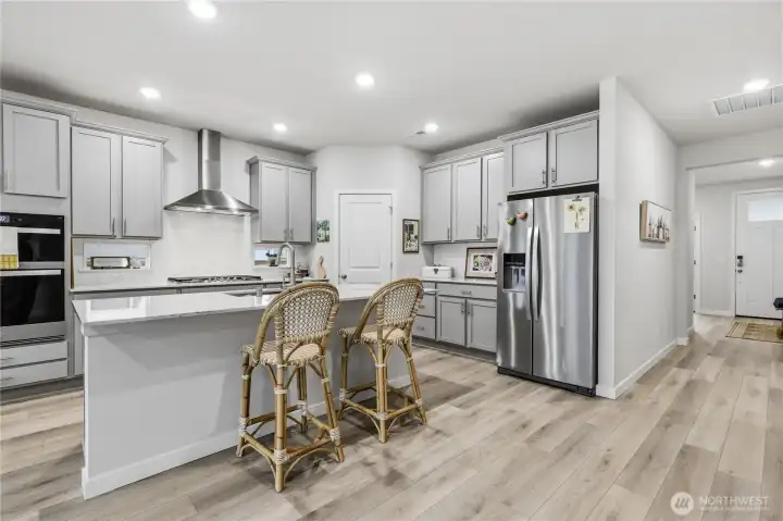 The spacious, gorgeous kitchen with stainless steel appliances and quartz counter tops.