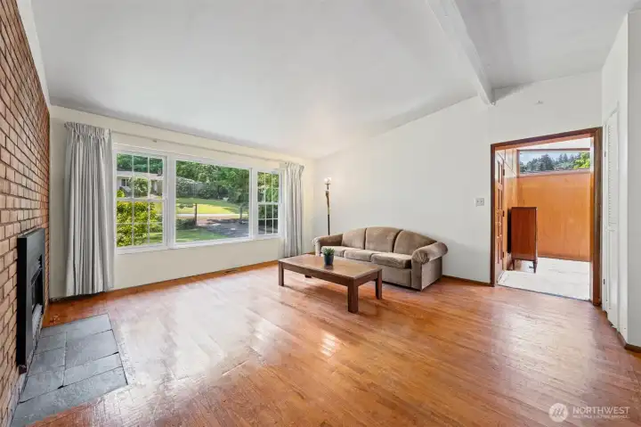 Spacious open living room with vaulted beamed ceilings, original hardwoods, and direct access to the outdoors — all in a single-story Bellevue WA rambler priced for a buyer ready to personalize. Located in Eastgate near Cougar Mountain trails, South Bellevue Community Center, and top-rated Newport High School