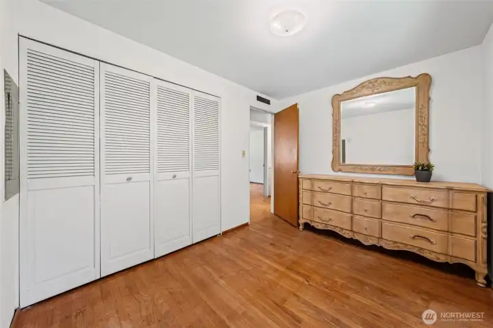 Bedroom 3 features a wall-to-wall double closet with louvered doors and original hardwood floors throughout — solid storage for a single-story home. Plenty of room to downsize comfortably without sacrificing space or function.