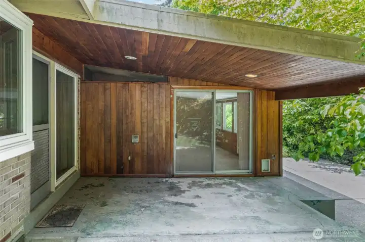 The covered back entry of this Eastgate Bellevue rambler features a beautiful wood-planked ceiling, sliding glass door access to the rec room, and a concrete patio that's ready for outdoor furniture the day you move in. A private, protected outdoor living space in one of the Eastside's most sought-after single-story home neighborhoods.