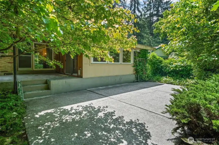 Tucked under a canopy of mature trees, the back patio of this private retreat that feels worlds away from the city — even though downtown Bellevue is just five miles away. This outdoor space is a blank canvas for buyers ready to landscape, entertain, and make it their own