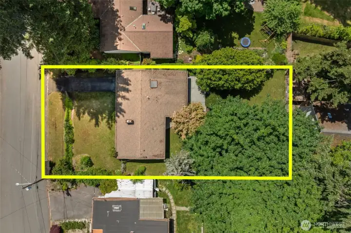 The full picture — an aerial view of this Eastgate Bellevue rambler with property lines highlighted, showing just how much lot you're getting in Bellevue. Single-story home, long private driveway, front yard, and a deep tree-lined backyard that stretches well beyond the footprint of the house. For buyers searching for a single-family home with land in the greater Seattle area, this is the kind of lot that's increasingly rare at this price point on the Eastside — and it's all yours to shape.