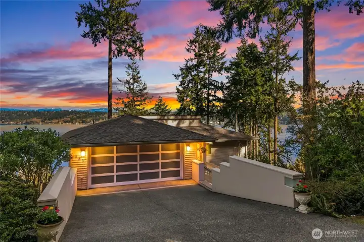 A warm welcome home, beautifully lit as the day winds down. EV charger in garage conveys. A warm welcome home, beautifully lit as the day winds down. EV charger in garage conveys.