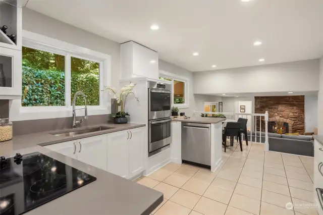 Remodeled open kitchen with high-end stainless-steel appliances, new quartz countertops, sink and fixtures along with freshly painted cabinets.