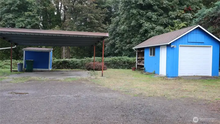 Large carport plus a single car garage and garden shed.