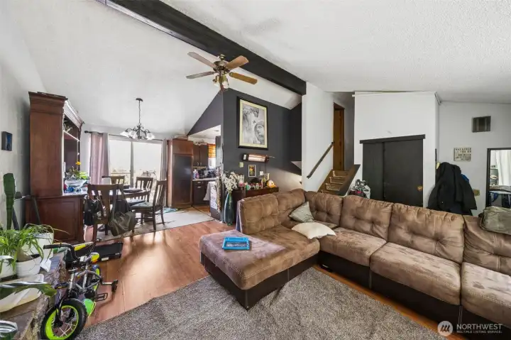 Open-concept main living area with vaulted ceilings, natural light, and seamless flow between living, dining, and kitchen spaces.
