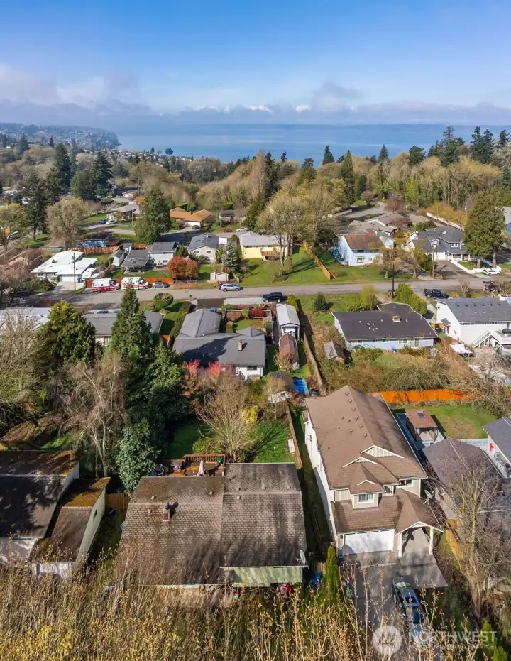 Elevated view capturing Puget Sound in the distance, showcasing the home’s position within an established neighborhood setting.