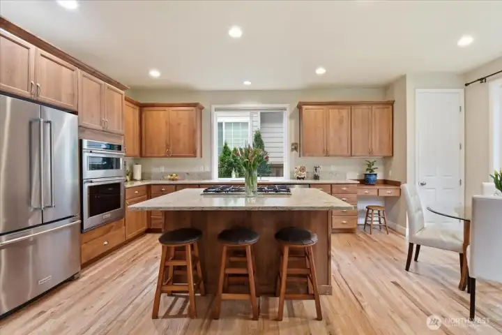 New stainless steel appliances shine alongside a center island topped with slab granite counters.