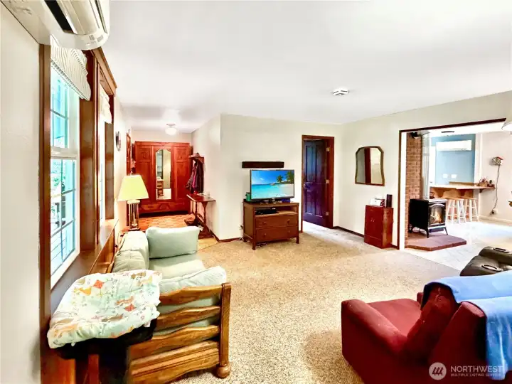 View of entry and living room. Large windows look out over front porch.
