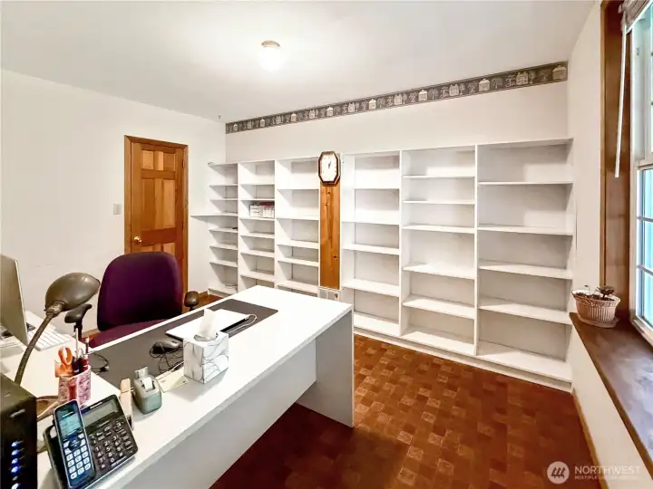 Ample office off of living room with lots of shelving and large storage closet.