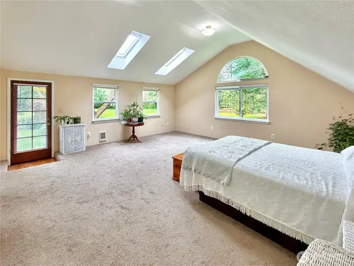 Huge primary with vaulted ceilings, skylights and access to outside.
