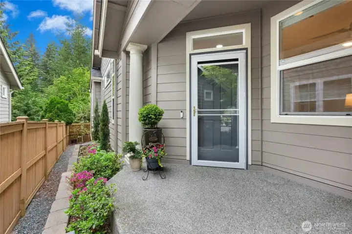 Greet guests at this large covered entry. Beautiful Andersen storm door with retractable screen installed in 2024. Irrigated planting space for your green thumb runs alongside of home.