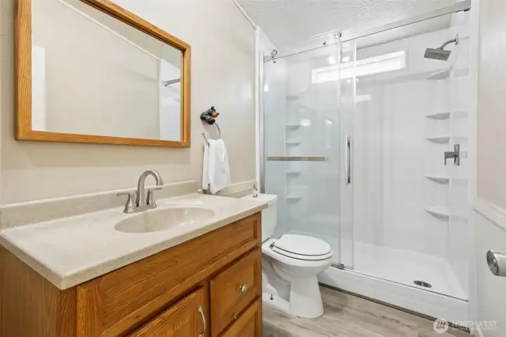 Freshly updated main guest bath featuring a new shower, flooring and toilet. The refreshed shower adds both style and convenience. It’s ready for guests or everyday use.