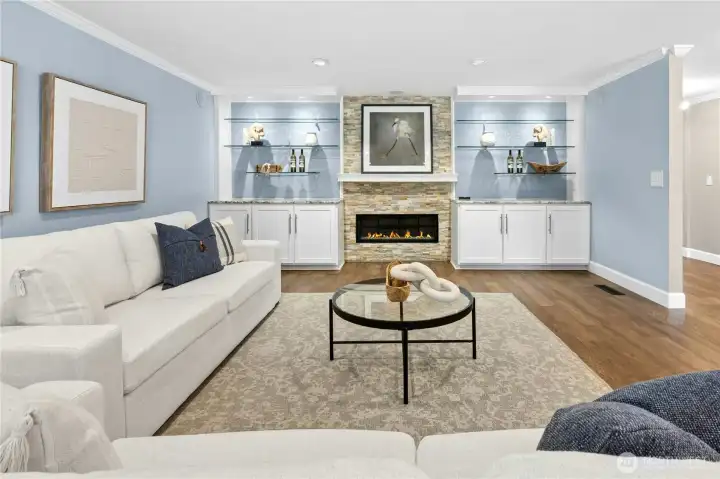 The living room blends warmth and elegance with crown molding, rich wood flooring, and a gas fireplace flanked by handy built-ins. Want to make this your media room? TV mount and built-in surround sound are already installed.