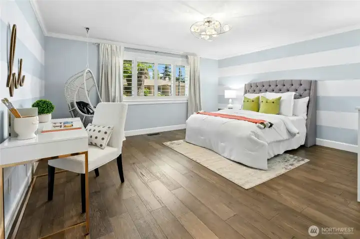 This spacious main floor bedroom feels bright and welcoming, with plantation shutters and custom decor. Clean finishes and an airy layout create a comfortable setting for guests, work, or everyday living.
