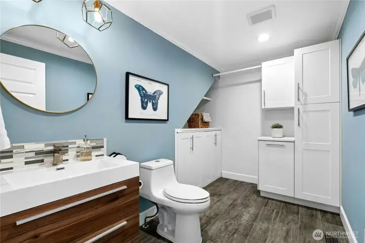 The main floor laundry and half bath combine style and function with modern finishes, abundant storage, and a thoughtfully designed layout. Custom cabinet doors cleverly conceal the washer and dryer when not in use, keeping the space polished and streamlined.