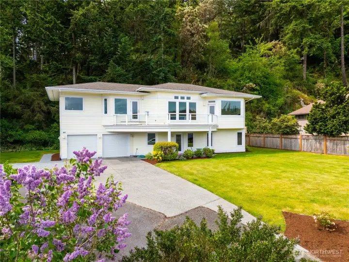 This stunning home offers a bright and airy upper-level living space, with large windows framing beautiful natural surroundings, a spacious yard, and a peaceful, private setting.