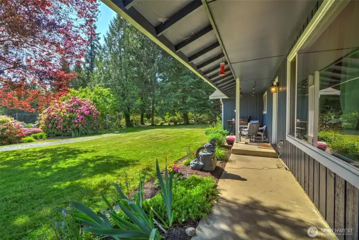 Covered front porch with gorgeous green lawn stretching out before you