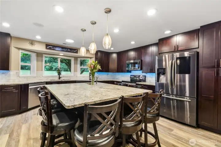 Massive kitchen island with granite countertops and sink — made for gathering