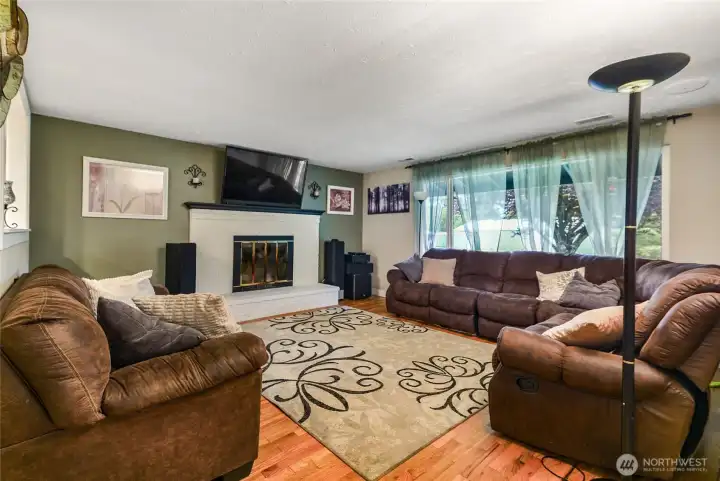 Expansive living room with cozy fireplace and rich hardwood floors