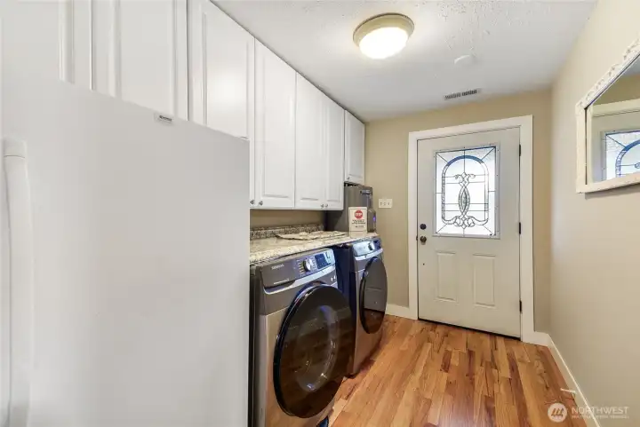 Oversized laundry room with cabinetry, washer/dryer, and exterior access