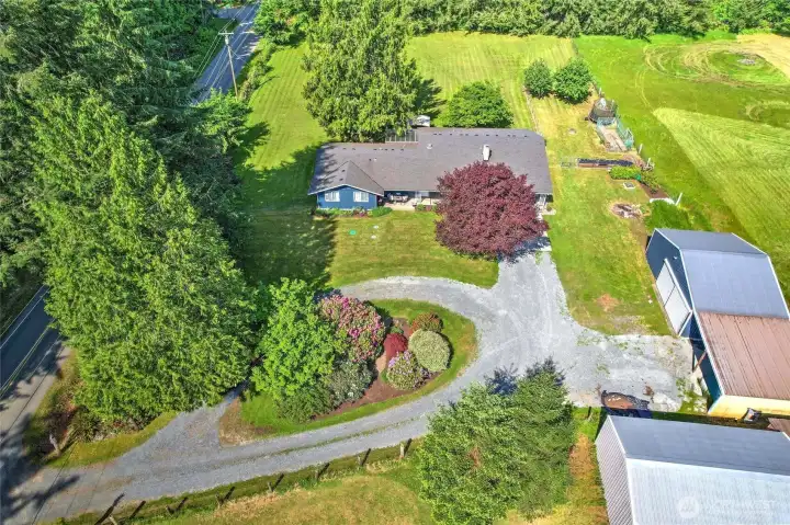 Aerial view — home and shop tucked into a private, lush green setting