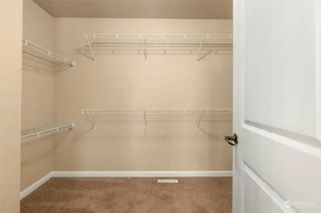 walk in closet tucked away in the primary bathroom