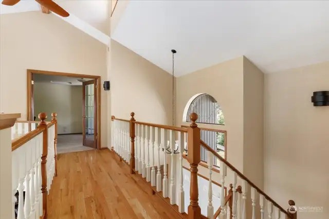 Vaulted ceilings, hardwood skywalk, and abundant natural light guide you to the primary bedroom or the second  bedroom.