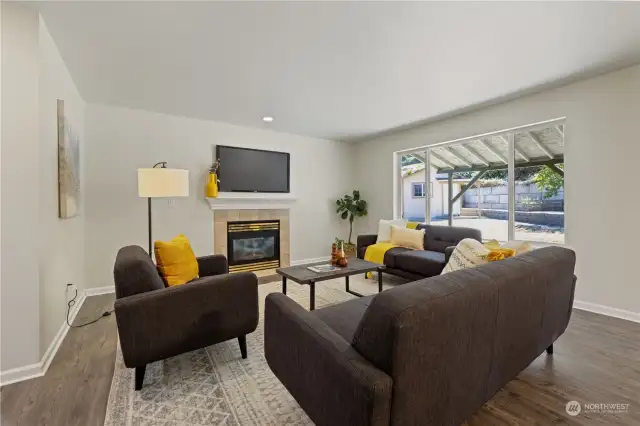 Large cozy living room with view of massive backyard. Enjoy the warmth of the fireplace.