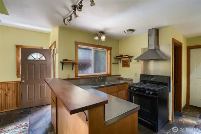 Chef kitchen with Stainless steel counters and propane stove with hood.