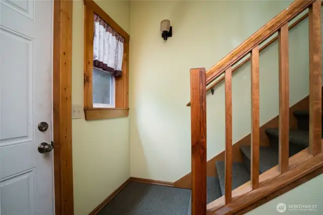 Wood trim and window casings, stairs lead to loft above.