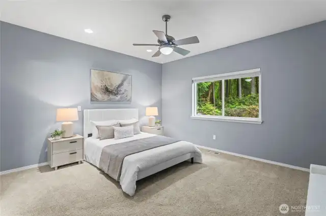 The spacious primary suite features freshly cleaned carpets and picturesque views through the sunlit window.