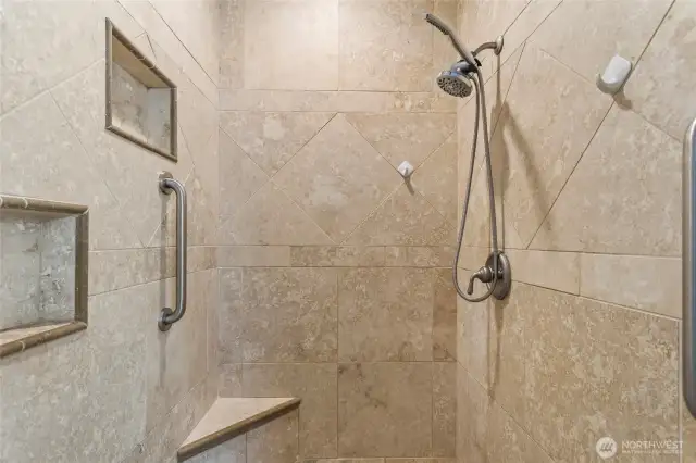 A fully tiled walk-in shower in the primary bathroom.