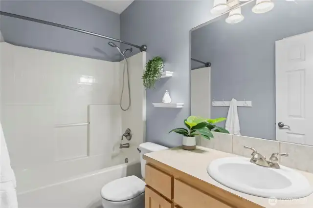 The main bathroom provides ample storage and a tub/shower.