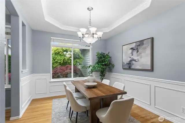 The arched entries into this space complement the coffered ceiling. A large sunny window brings light into this dining room.