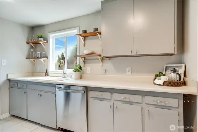 Stylish open shelving complement the natural light from the window. No lack of storage in these classic cupboards!