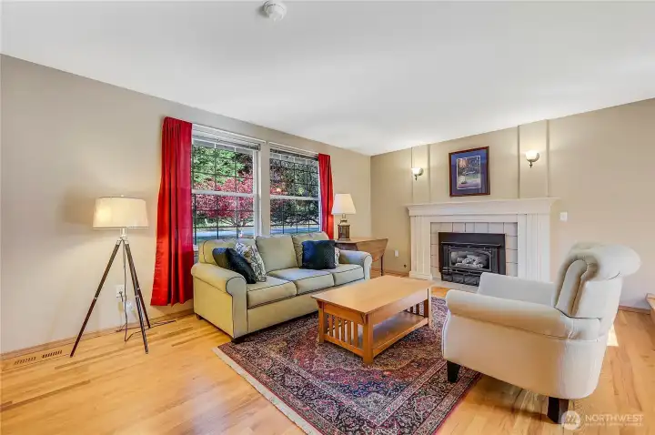 Light and bright, the formal living room is warm and inviting with real hardwood floors, a cozy propane fireplace and picture windows.