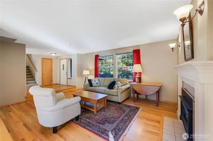 The formal living room with the front door in the background. This cozy space enjoys real hardwood floors, and a propane fireplace.