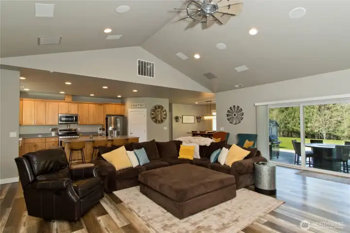 Spacious living room with vaulted ceilings, built-in speakers, and open flow to the kitchen.