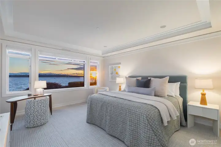 Spacious primary suite with sweeping west-facing lake views and stunning sunsets, featuring a spa-like ensuite with double vanity, soaking tub, walk-in shower, and a generous walk-in closet, and direct access to the large covered patio with views. Spacious primary suite with sweeping west-facing lake views and stunning sunsets, featuring a spa-like ensuite with double vanity, soaking tub, walk-in shower, and a generous walk-in closet, and direct access to the large covered patio with views.
