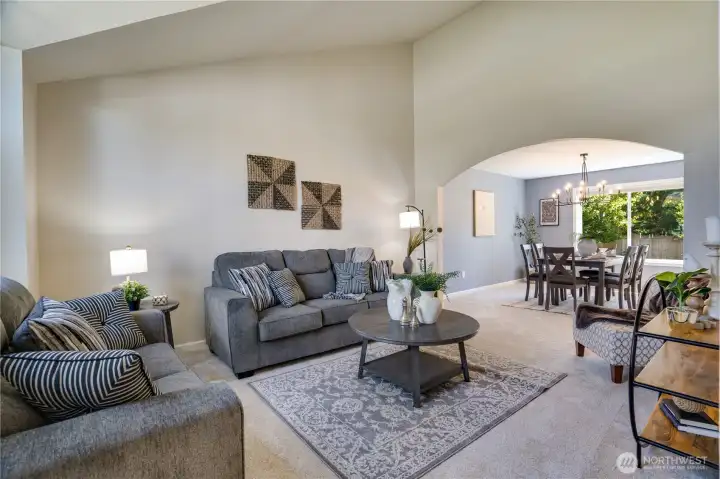 A graceful arched opening connects the living and dining rooms, while new carpet installed in 2026 adds warmth and comfort to this welcoming gathering space.