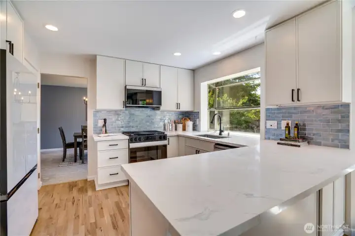 The completely refreshed 2025 kitchen combines generous prep space and bar seating with updated cabinetry and countertops to create a kitchen that's both beautiful and practical.
