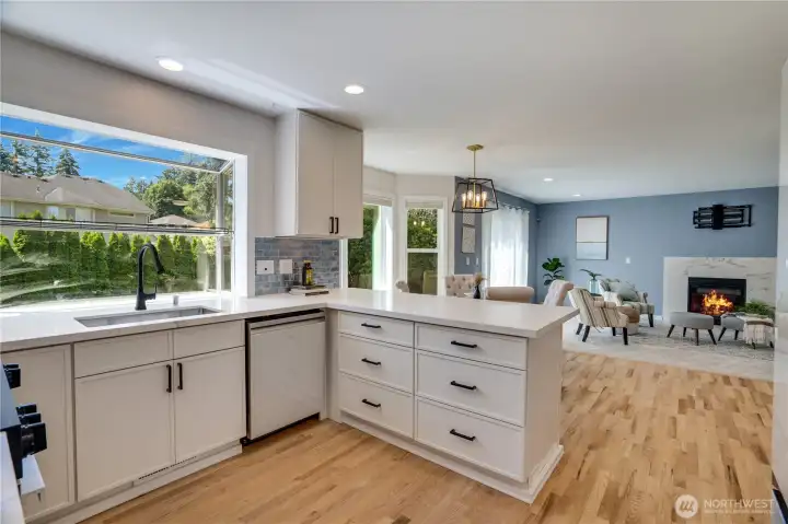 Refinished hardwood floors and updated main-floor lighting (2026) enhance the bright, open flow between the kitchen, breakfast nook, and family room—making everyday living and entertaining feel effortless.