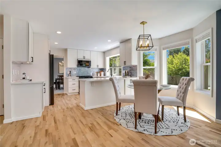 Sunlight fills the cheerful breakfast nook, where a graceful bow window creates an inviting spot for morning coffee, casual meals, or catching up at the end of the day.