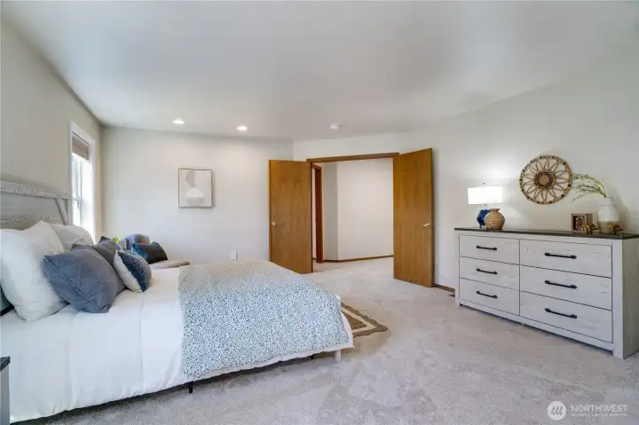 Looking back toward the elegant double-door entry, the expansive primary suite offers exceptional flexibility for a sitting area, reading nook, or home fitness space.