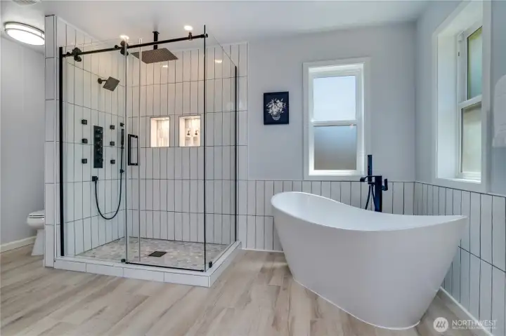 Beautifully remodeled in 2026, the spa-inspired primary bath features a freestanding soaking tub, oversized walk-in shower, and striking black fixtures for a relaxing everyday escape.